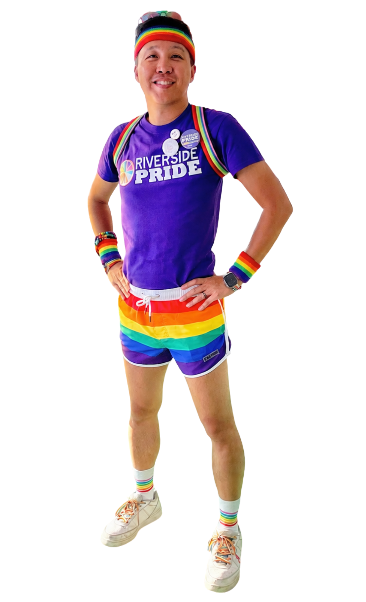 Ray standing in a Riverside Pride shirt, rainbow shorts, and rainbow accessories